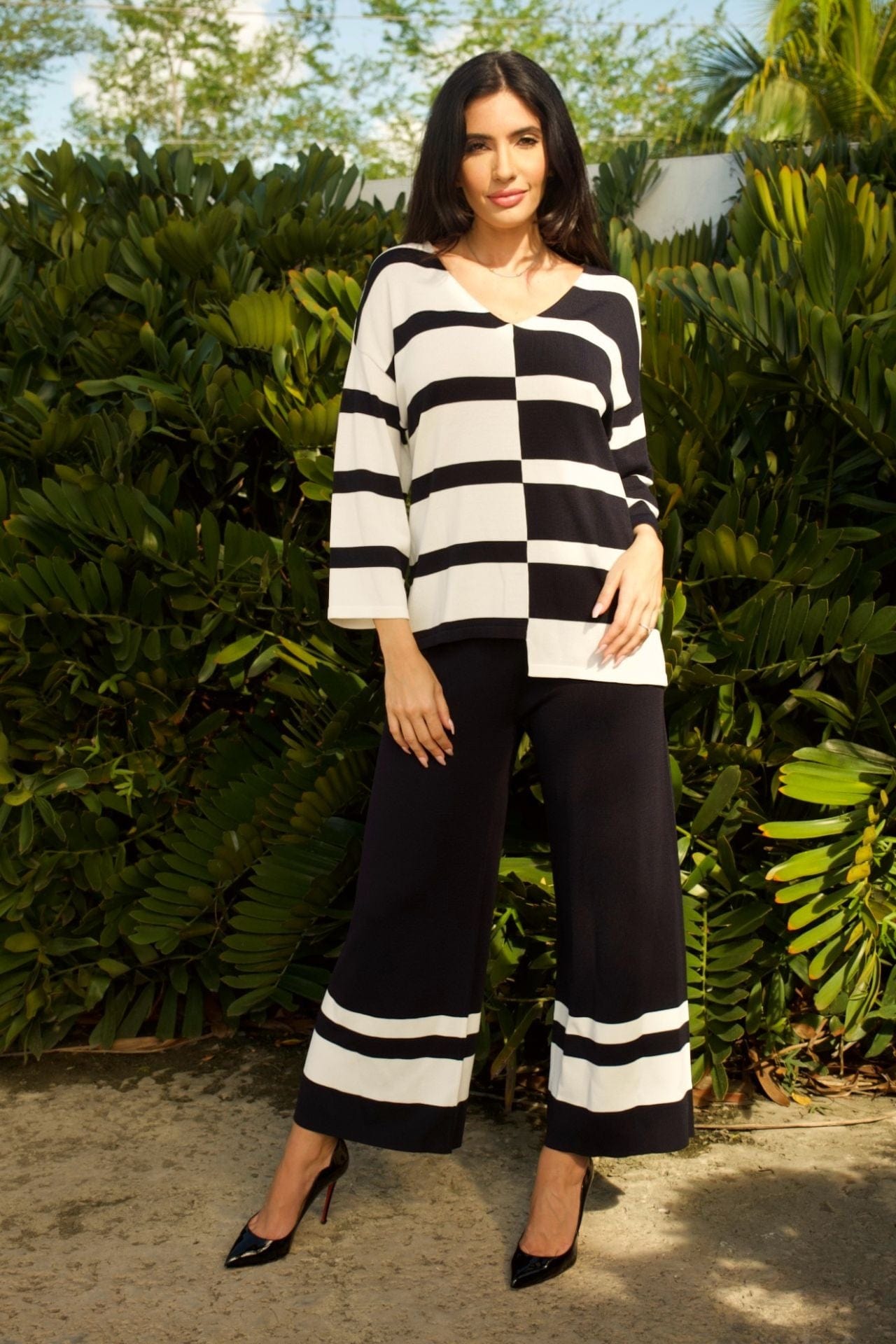 Woman wearing navy and white striped V-neck top with matching wide-leg pants set.