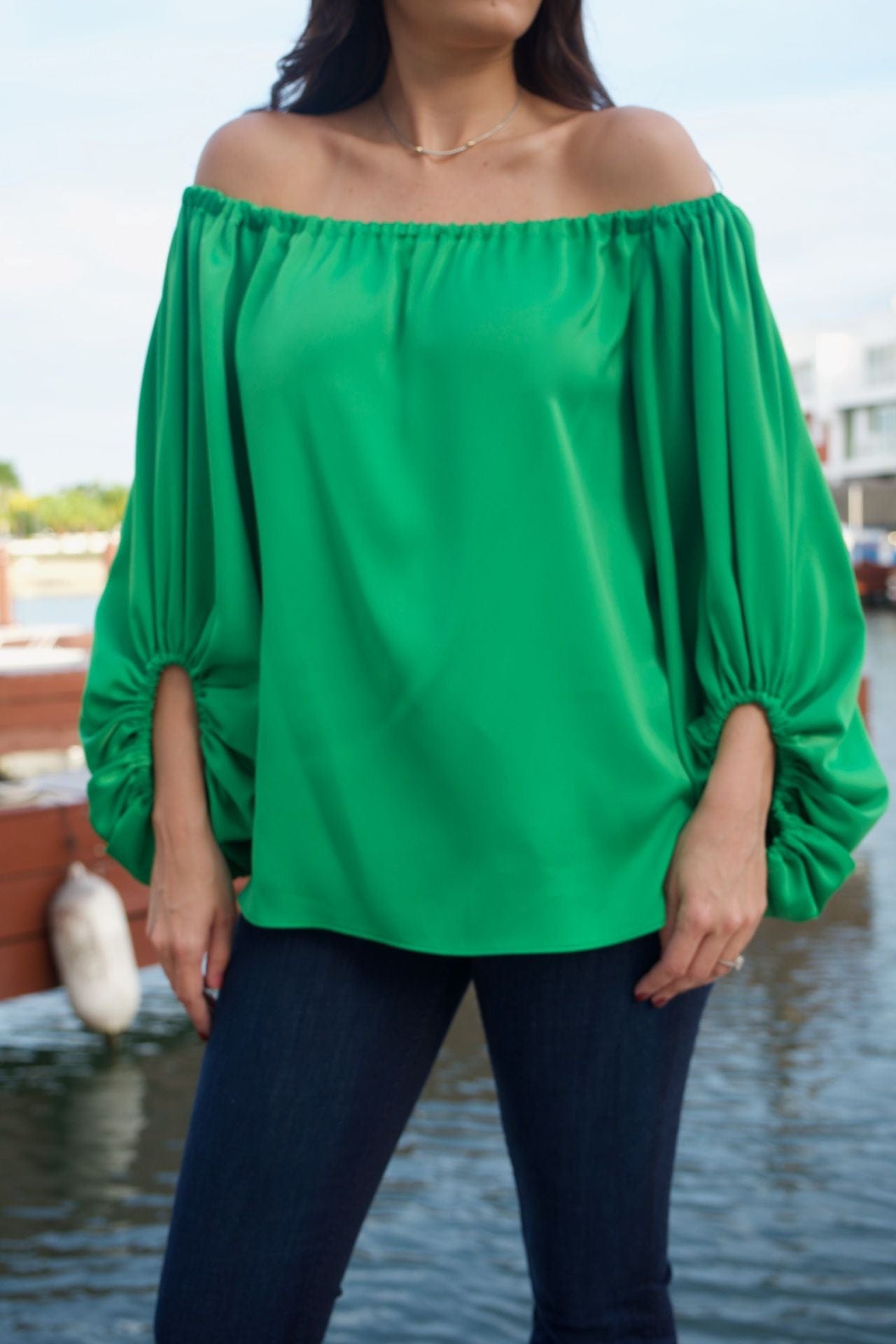 Close-up of the satin-like emerald fabric and sleeve detail.