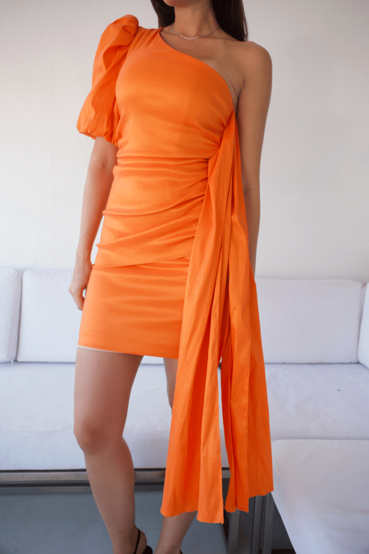 Close-up of a one-shoulder side-ruched cocktail dress, highlighting the intricate ruched detailing and luxurious fabric texture.