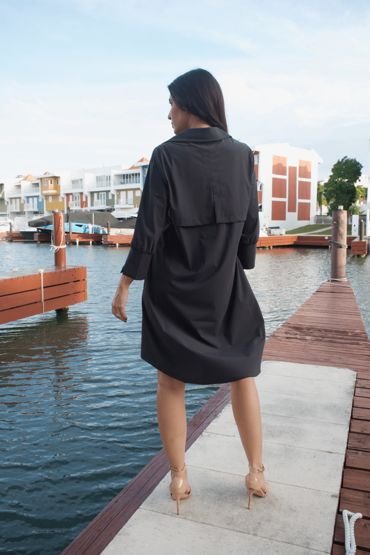 Back view of a women's zip-up knee-length charcoal dress jacket, showcasing a tailored design with a clean finish and a flattering fit.