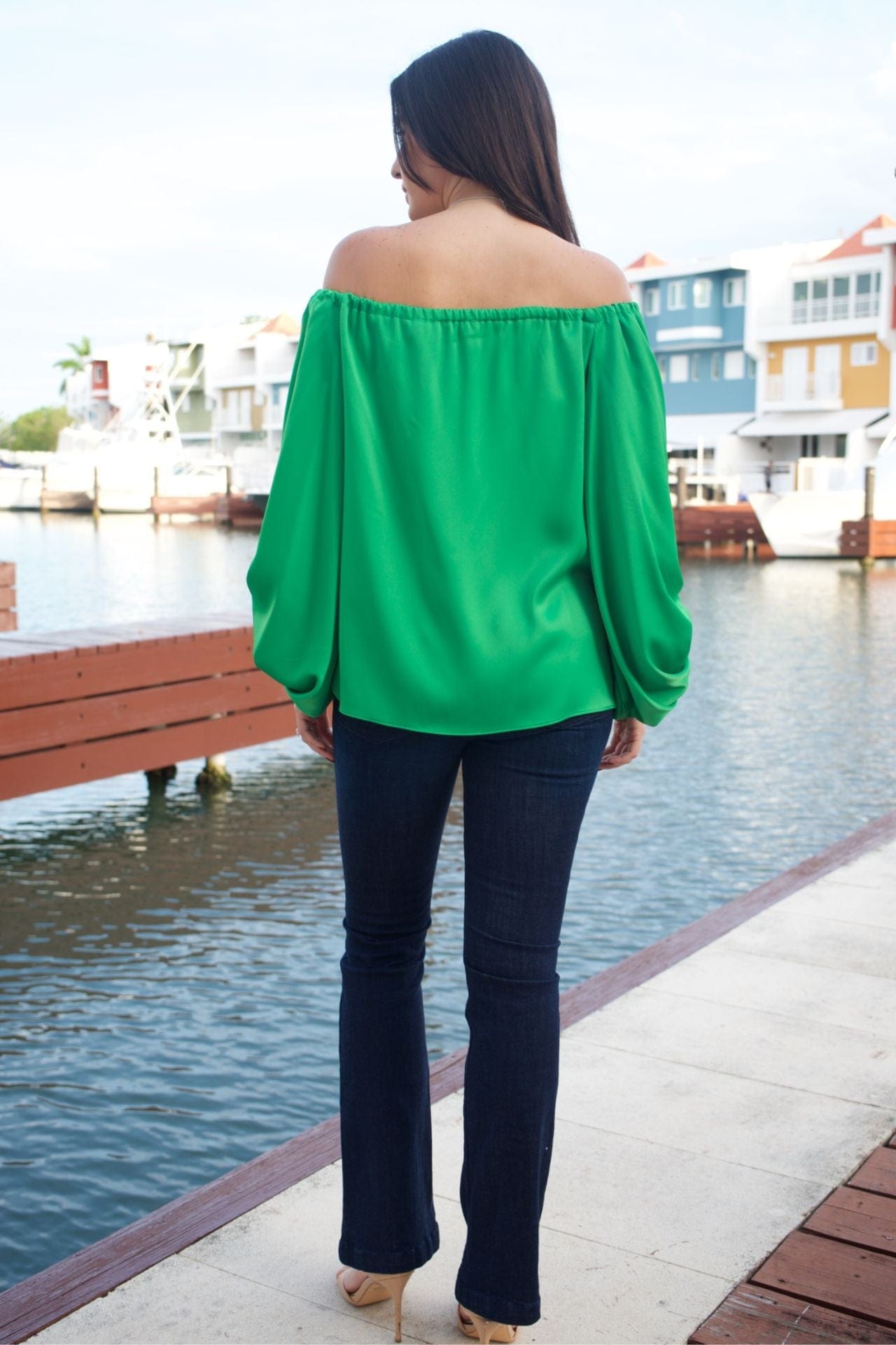 Back view of emerald green off-the-shoulder top, showing sleeve volume and neckline.