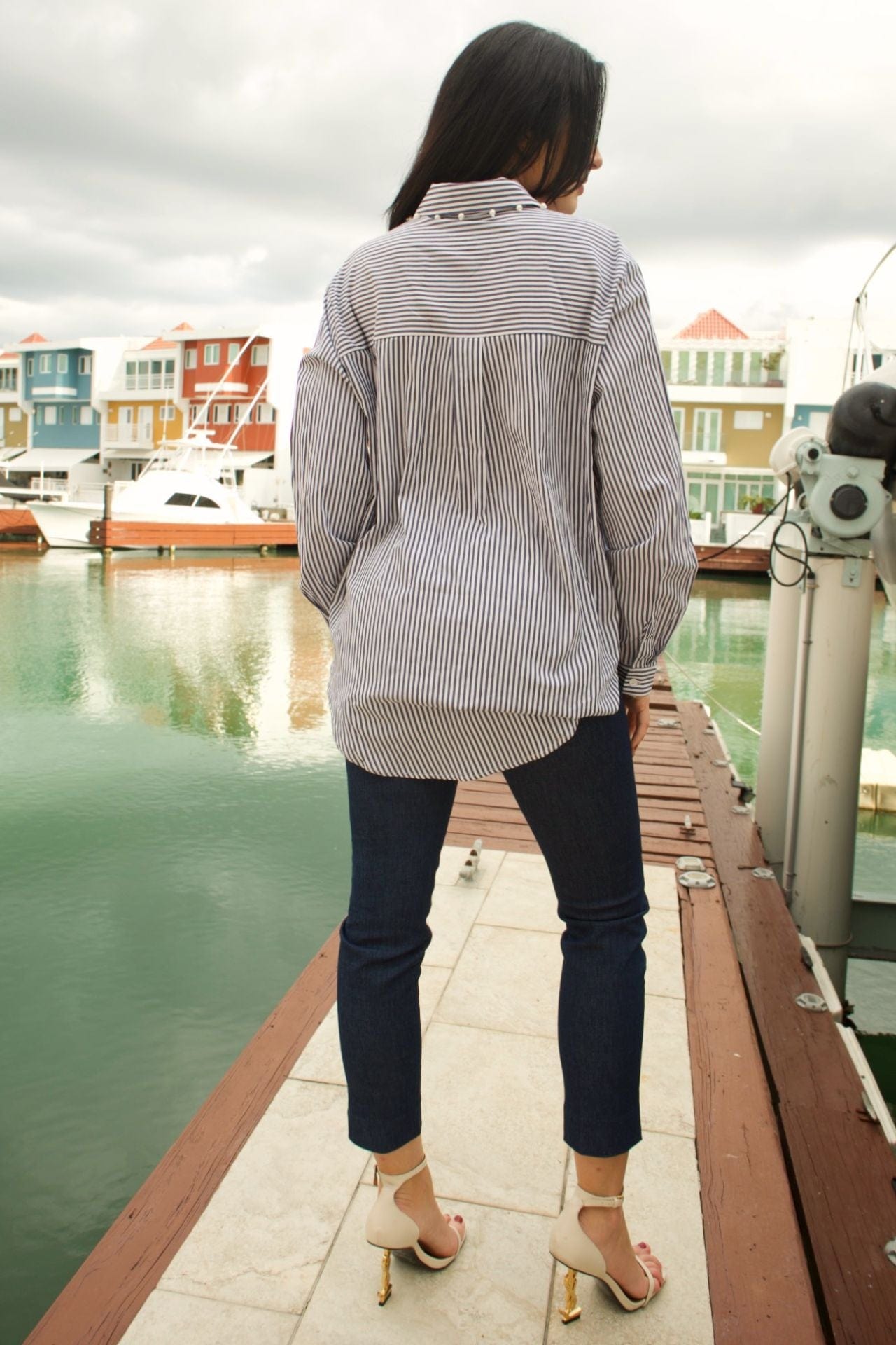 Back view of striped navy and white blouse with clean hem and long sleeves