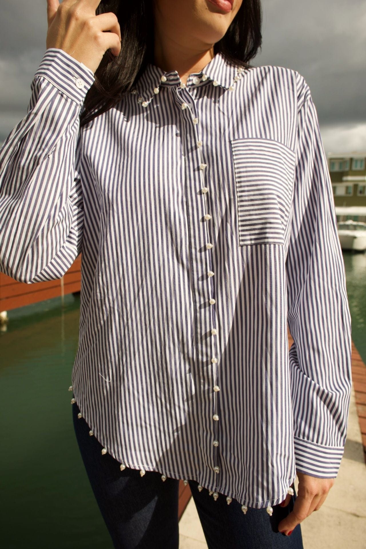 Close-up of pearl trim detail on striped long-sleeve blouse with front pocket