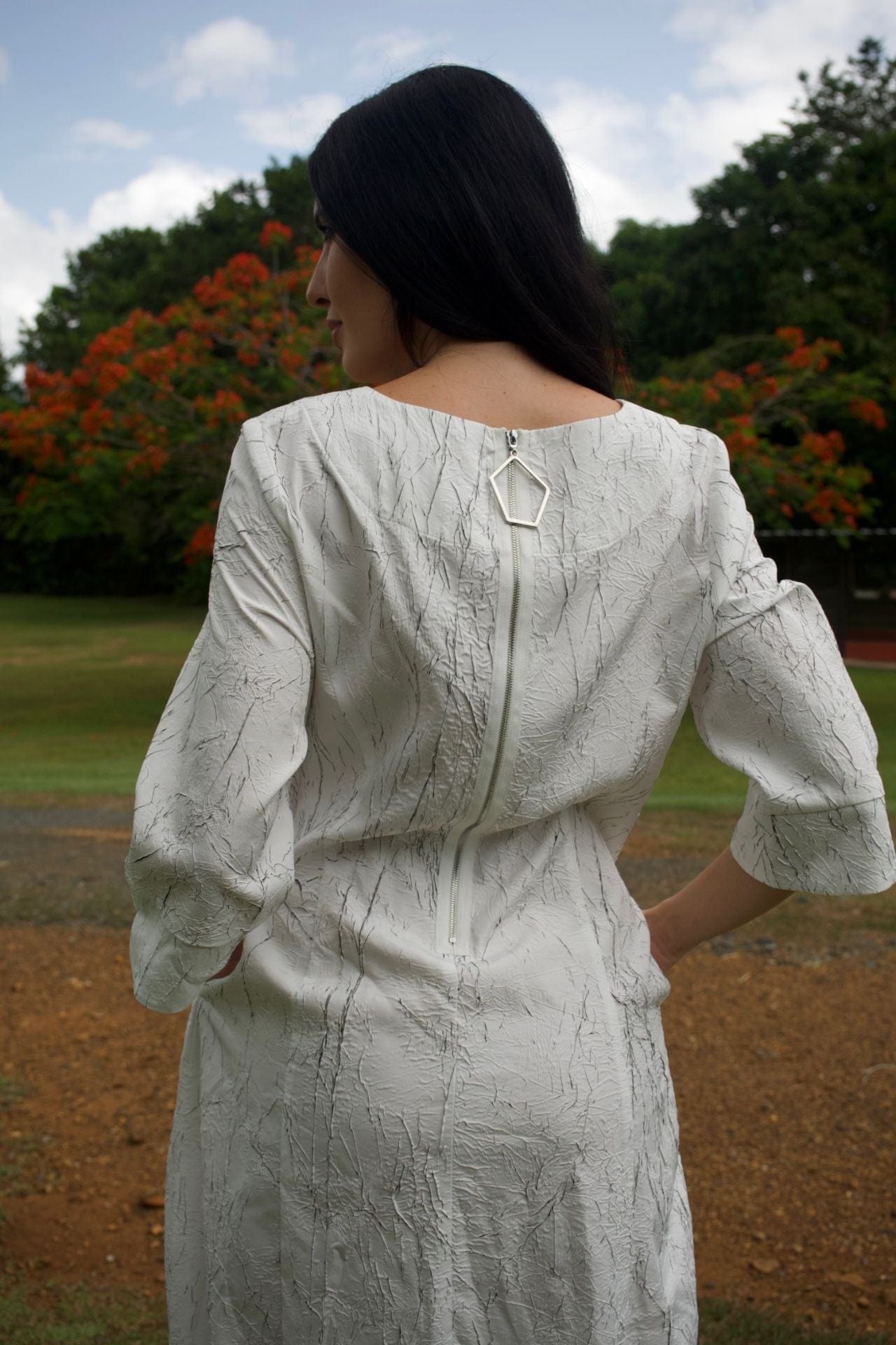 White and black textured modern dress – back view with zipper and contrast detail.