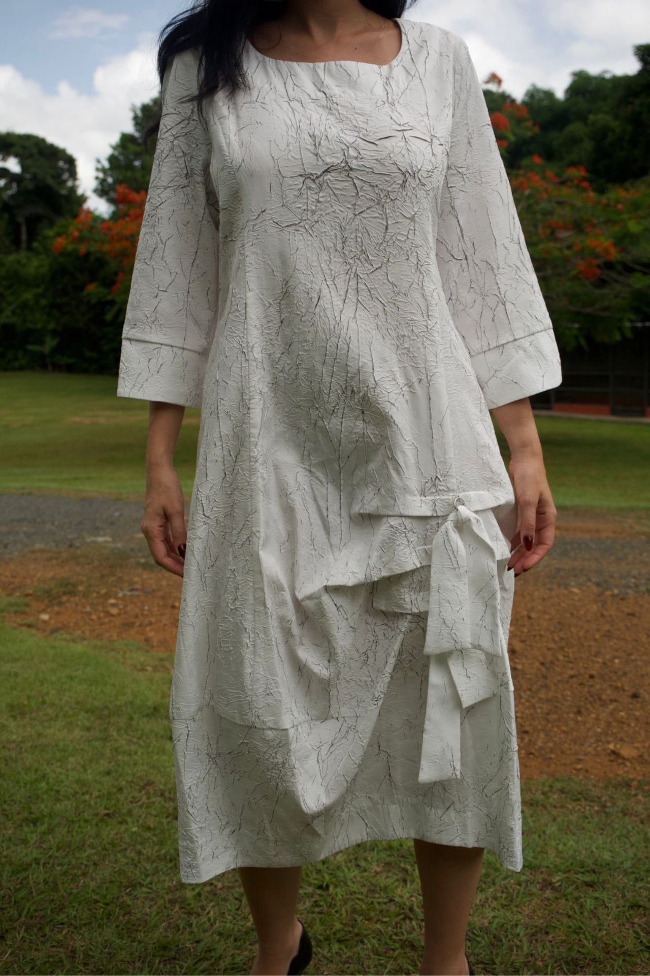 Close-up detail of textured modern dress – black and white weave with gathered hem.