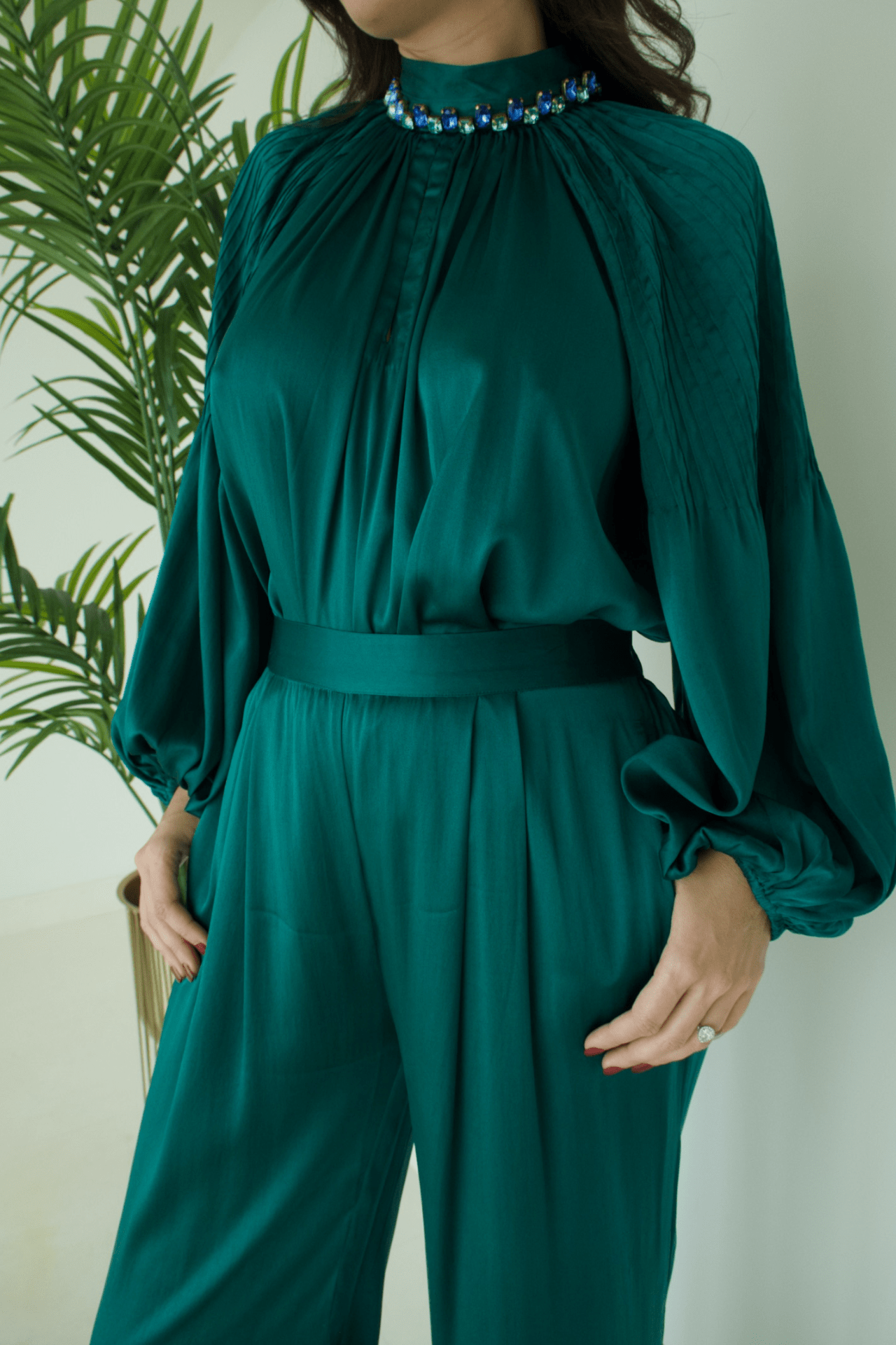 Close-up of the Women's Green Satin High Neck Top with Blue Stone Details and Pant Set highlighting the intricate blue stone accents and smooth satin fabric.