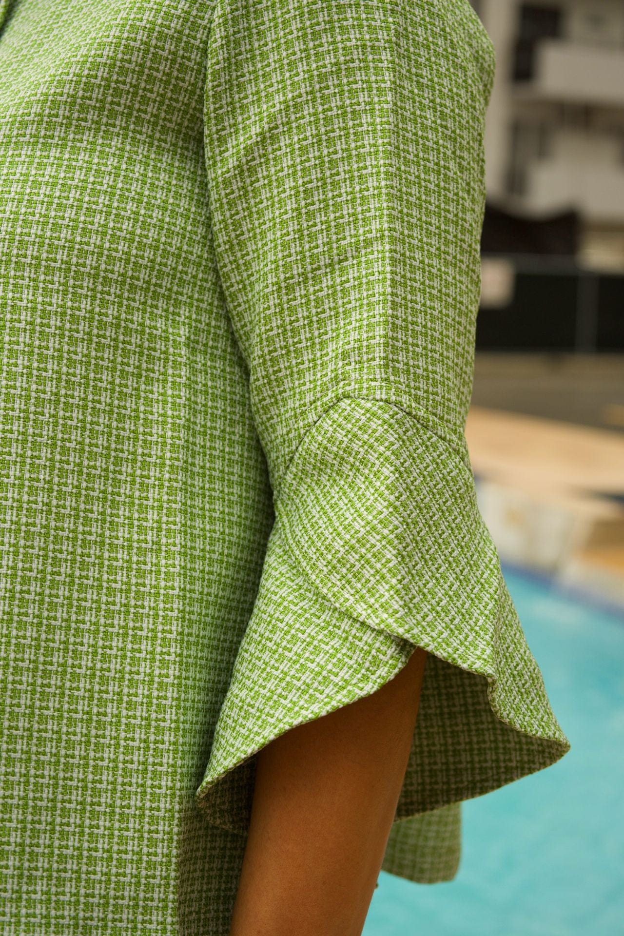 Close-up of textured tweed fabric and tulip sleeve hem

