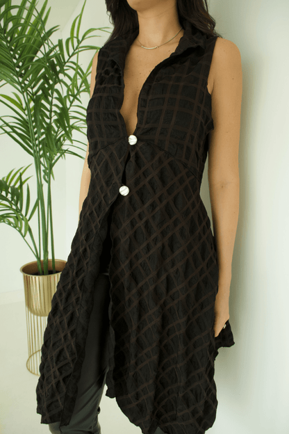 Close-up  of the women's black long vest fabric, highlighting its texture and button details.