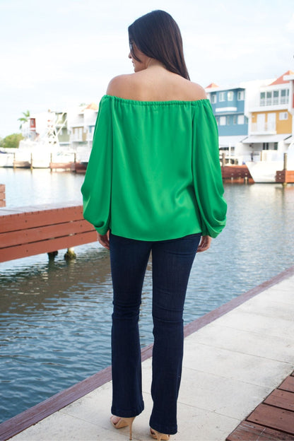 Back view of emerald green off-the-shoulder top, showing sleeve volume and neckline.

