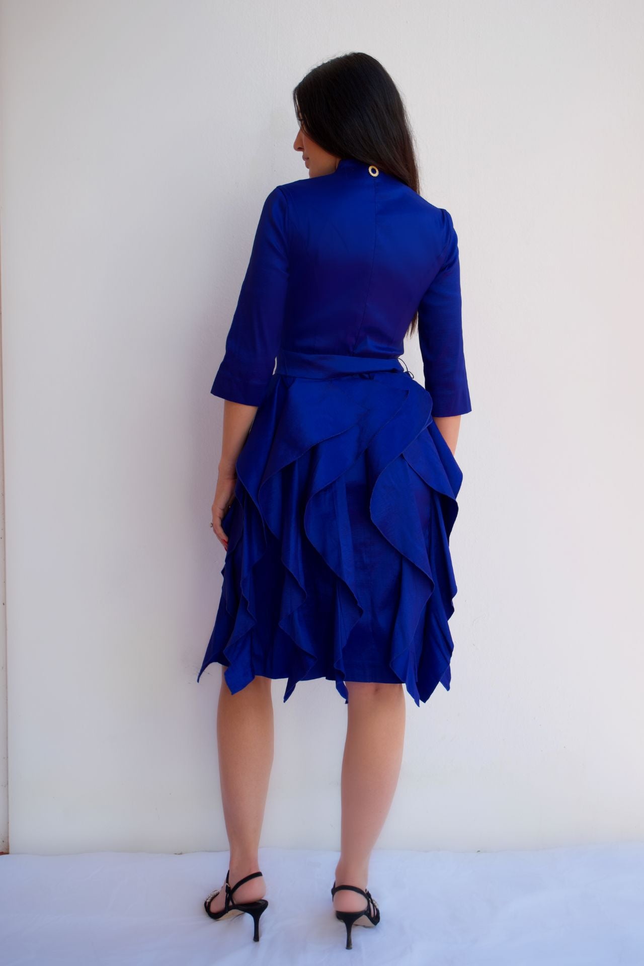 Royal blue taffeta dress with waist tie and ruffle skirt, styled for an elegant cocktail or special occasion look back view