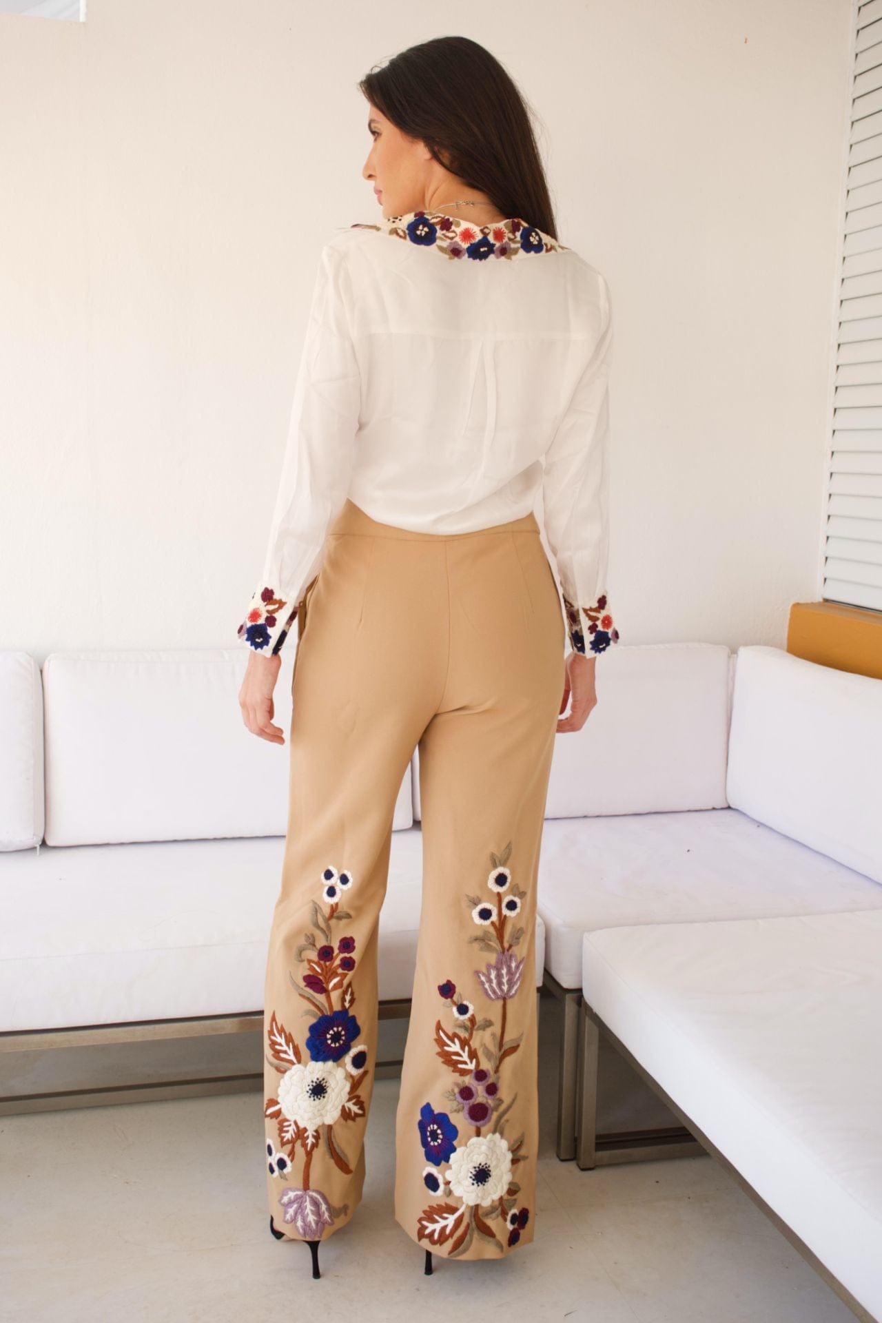 Back view of beige embroidered pants and blouse details.
