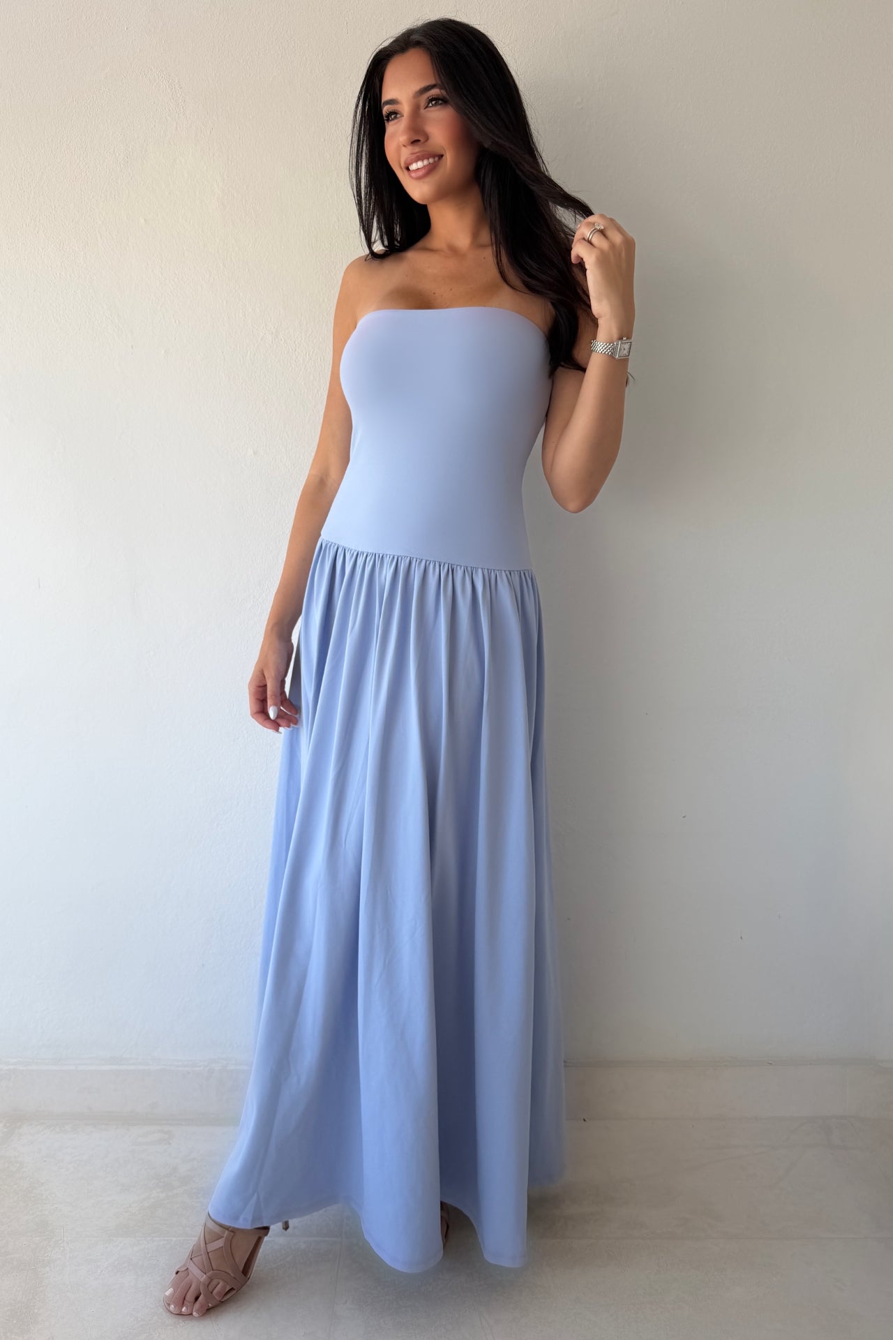 Model wearing the Blue Horizon Maxi Dress in soft sky blue featuring a strapless fitted bodice and flowing maxi skirt.