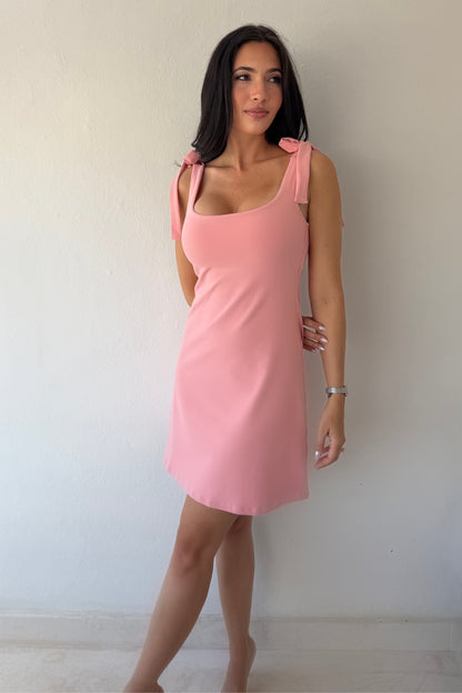 Model wearing the Blush Breeze Dress in soft blush pink featuring tie shoulder straps and a flattering A-line silhouette.