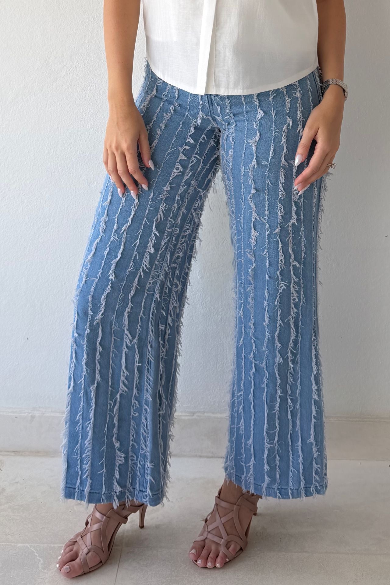 Model wearing textured wide-leg statement denim pants paired with a white statement blouse.