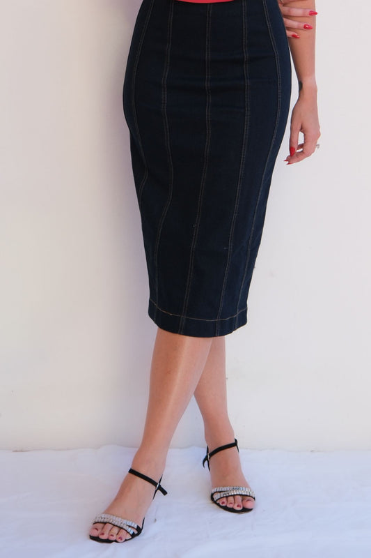 Elegant dark denim pencil skirt with contrast stitching, styled with a red strapless top for a chic day-to-night look.