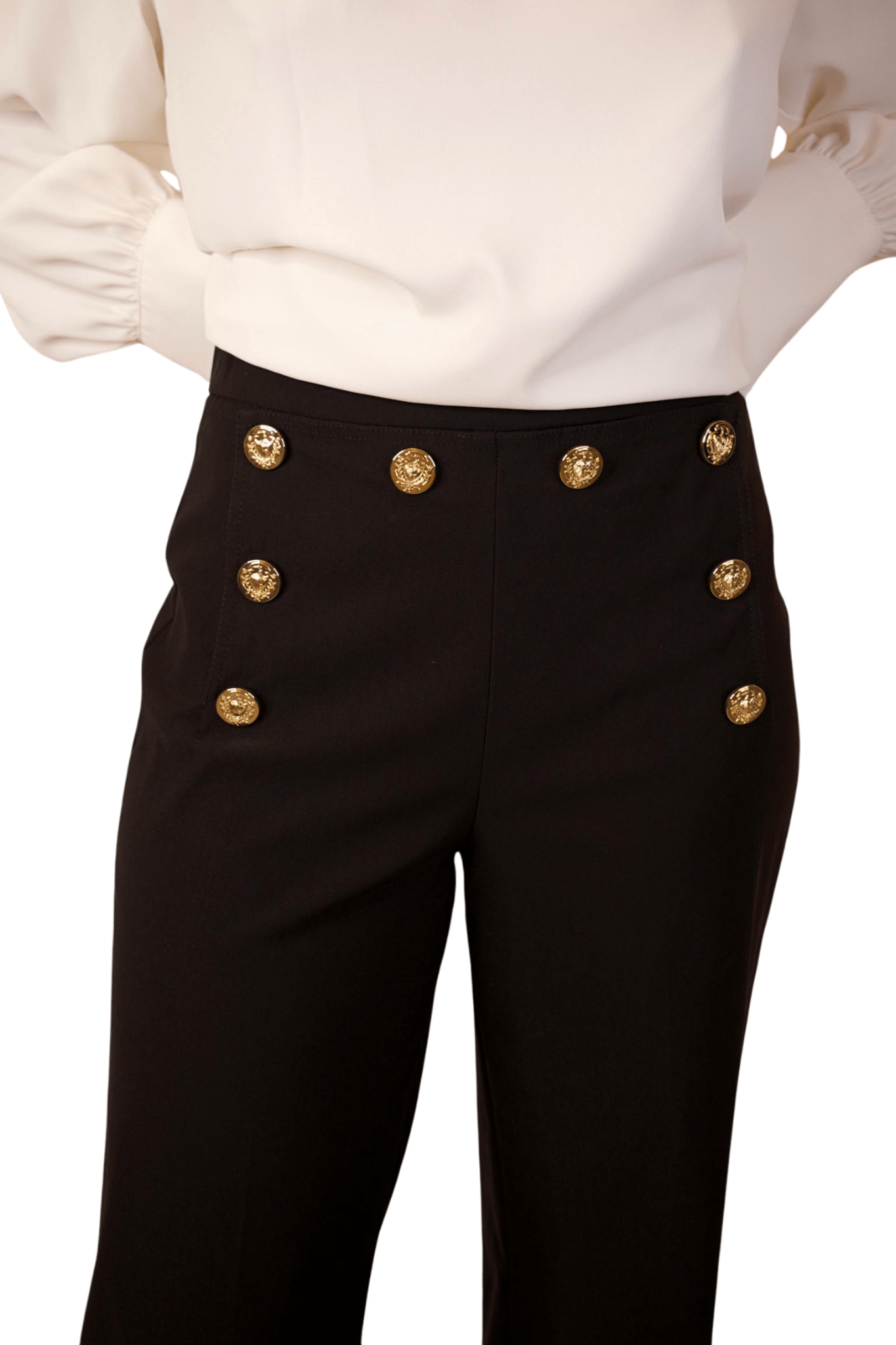 A woman wearing high waisted wide leg cropped sailor pants in black color with a white top.