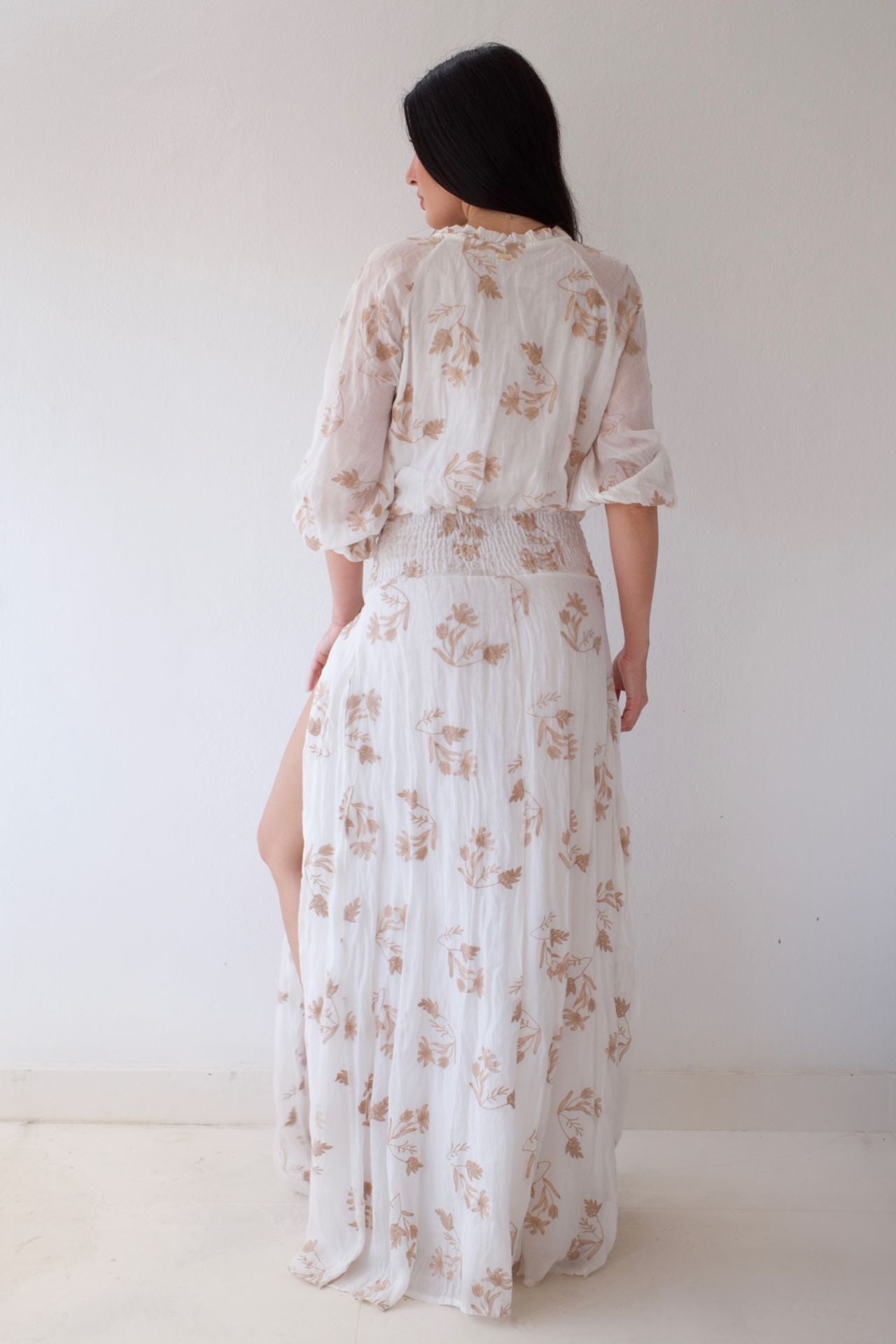 White floral dress with a deep neckline on a plain background