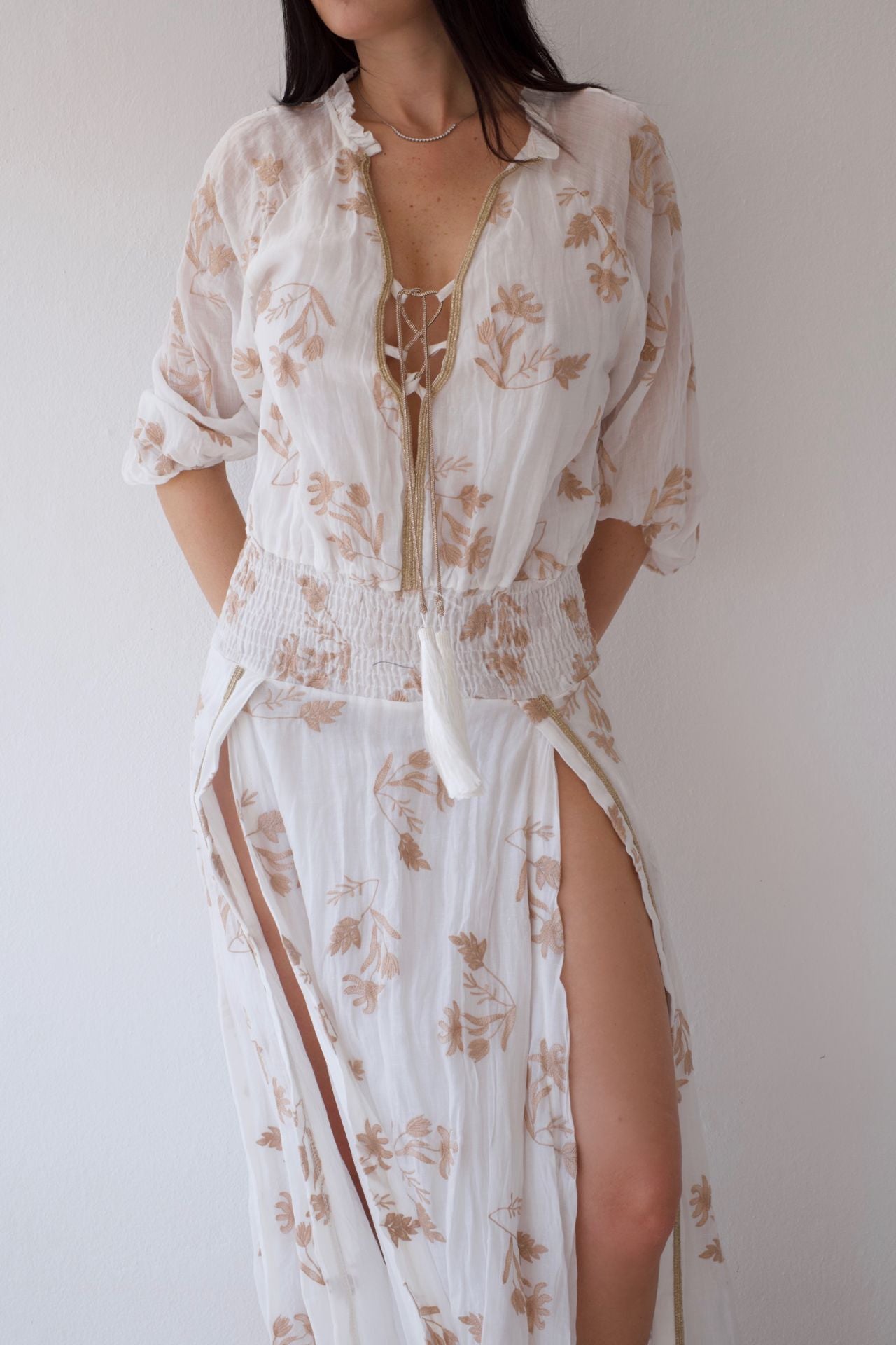 Woman wearing a floral cover-up dress against a plain background