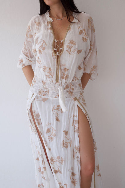 Woman wearing a floral cover-up dress against a plain background