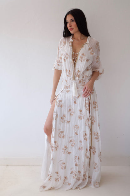 Woman wearing a white floral dress against a plain background
