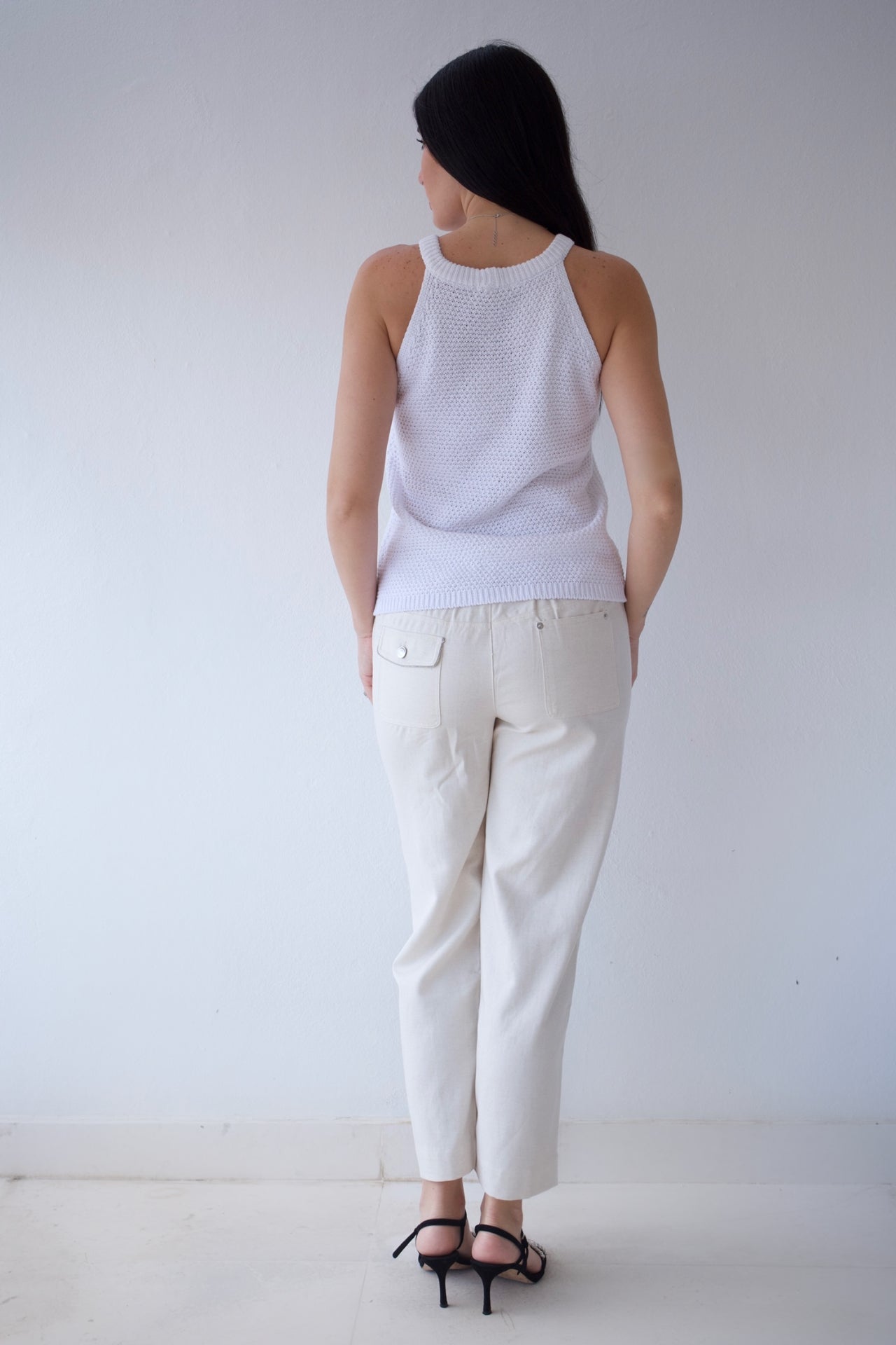 Ivory sleeveless knit top with floral appliqué shoulder details
