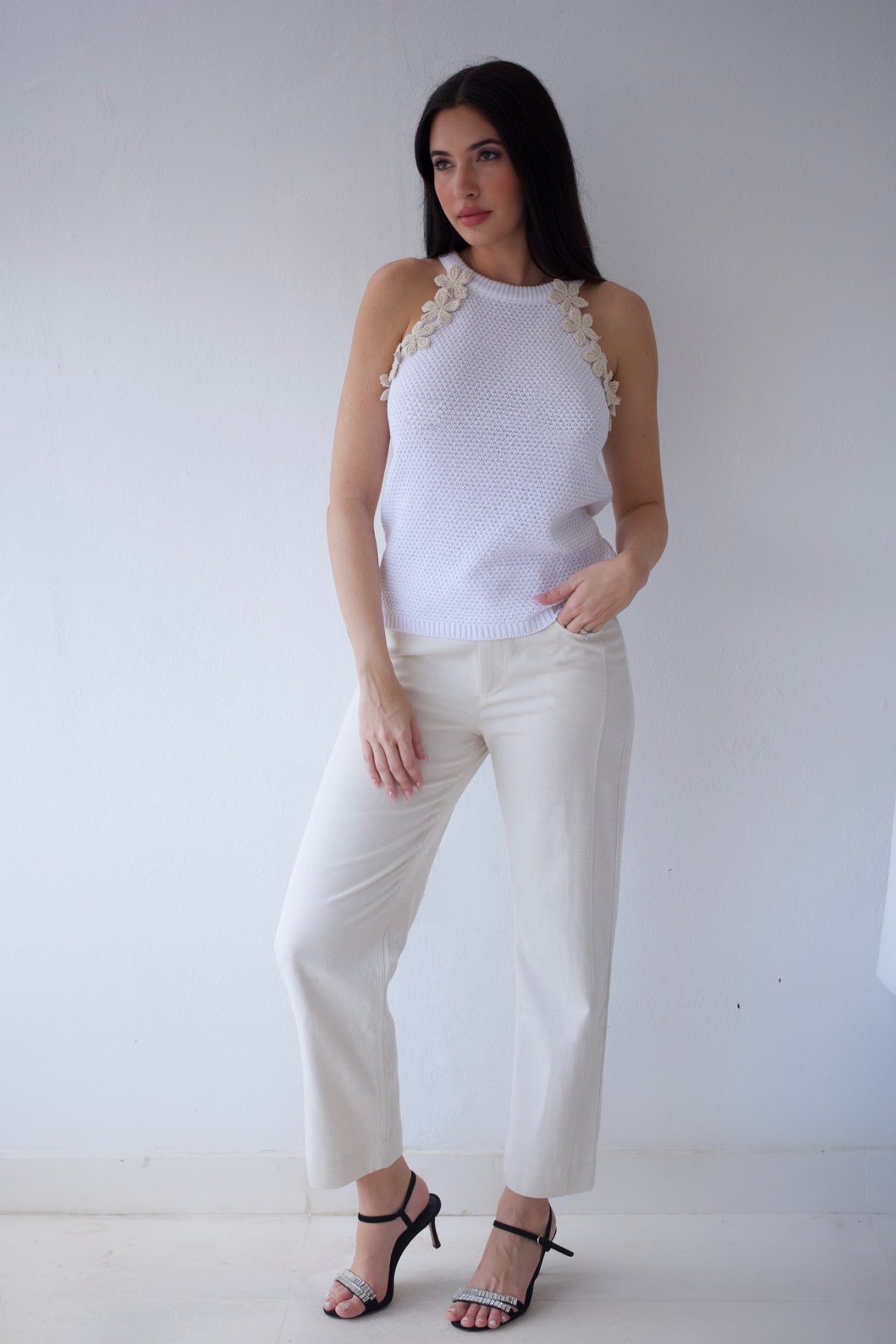 Ivory sleeveless knit top with floral appliqué shoulder details
