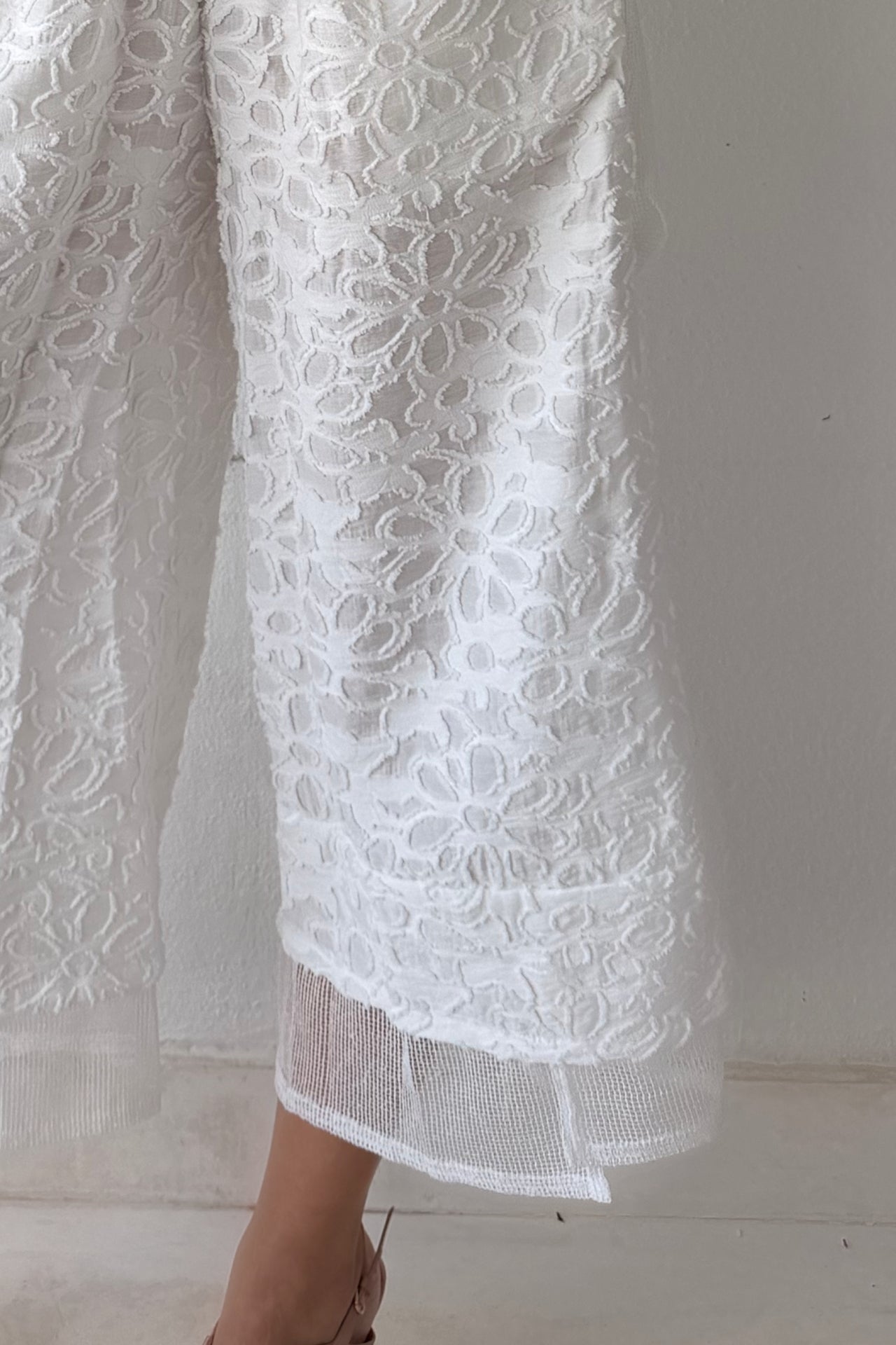 Model wearing the Ivory Garden Texture Set featuring a textured floral zip-front jacket and matching wide-leg pants in ivory.