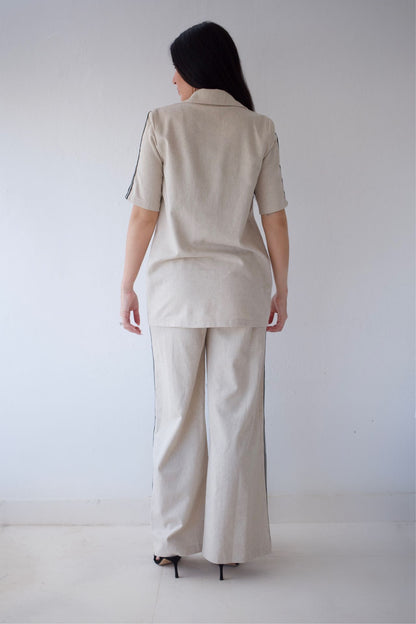 Person wearing a beige suit standing against a white background