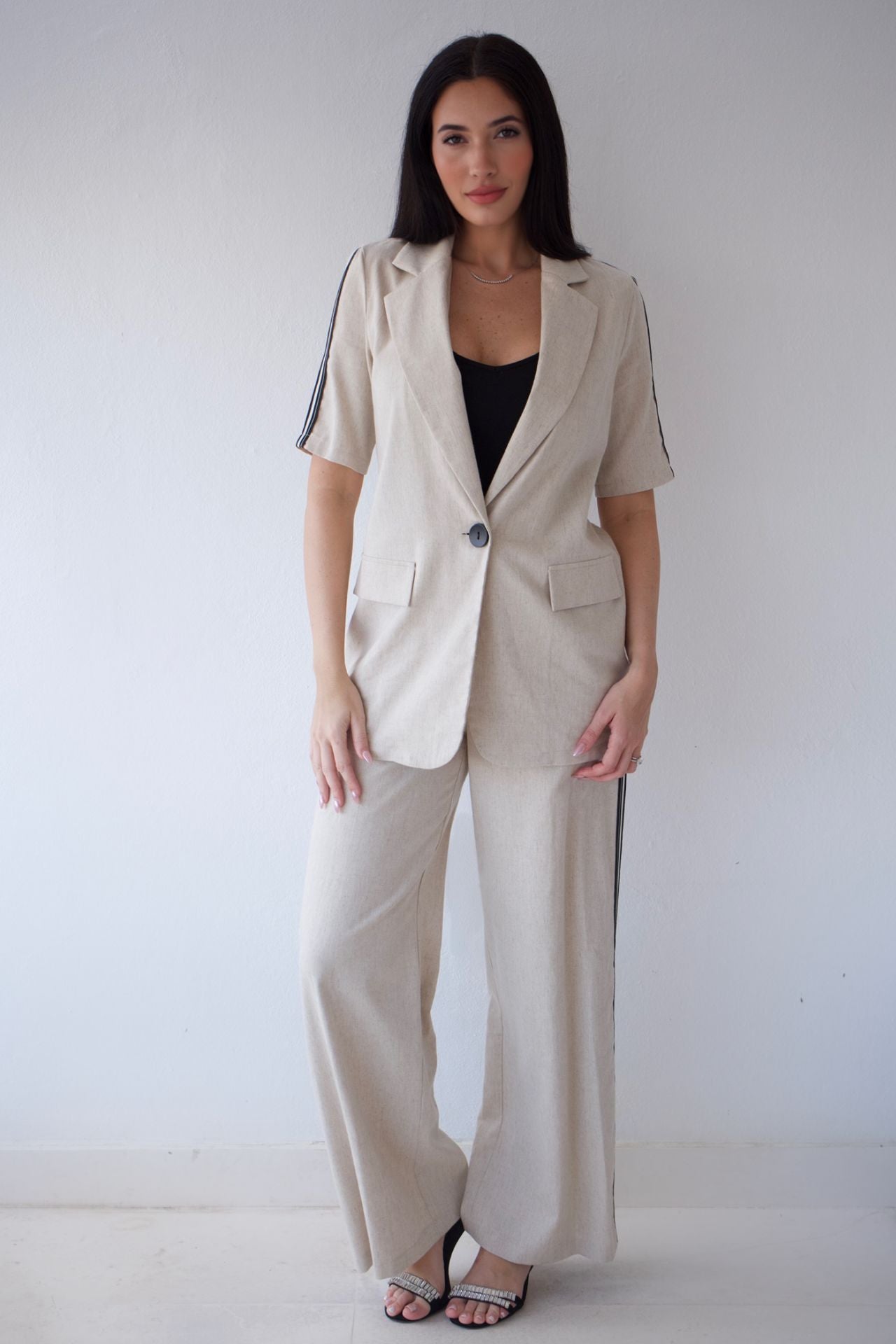 Woman wearing a beige suit with a plain background