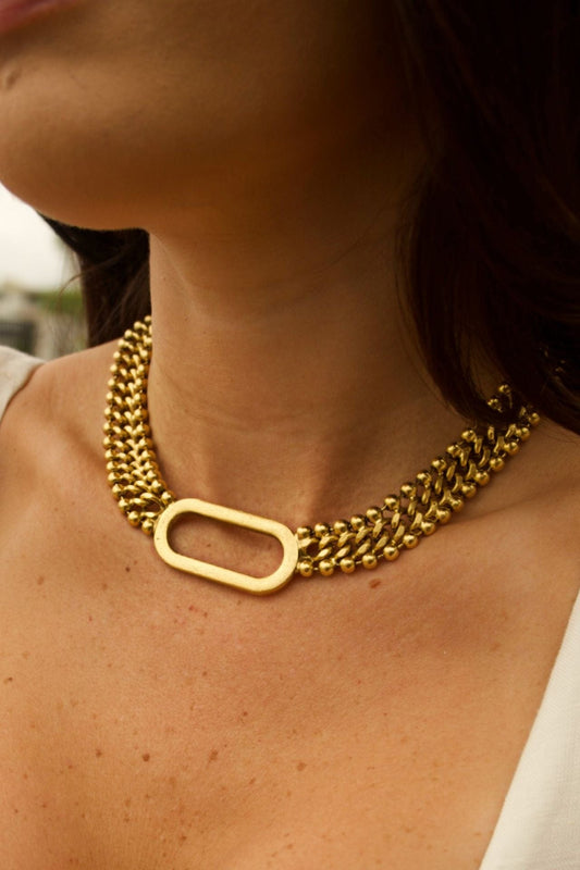 Gold chain necklace worn by a person