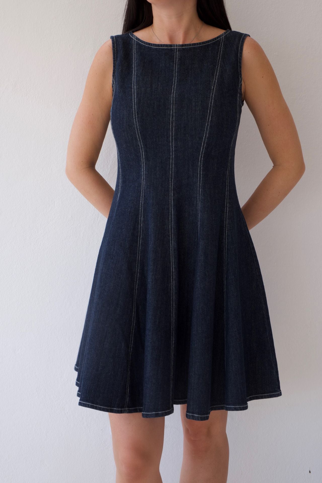 Dark denim dress worn by a person on a plain background