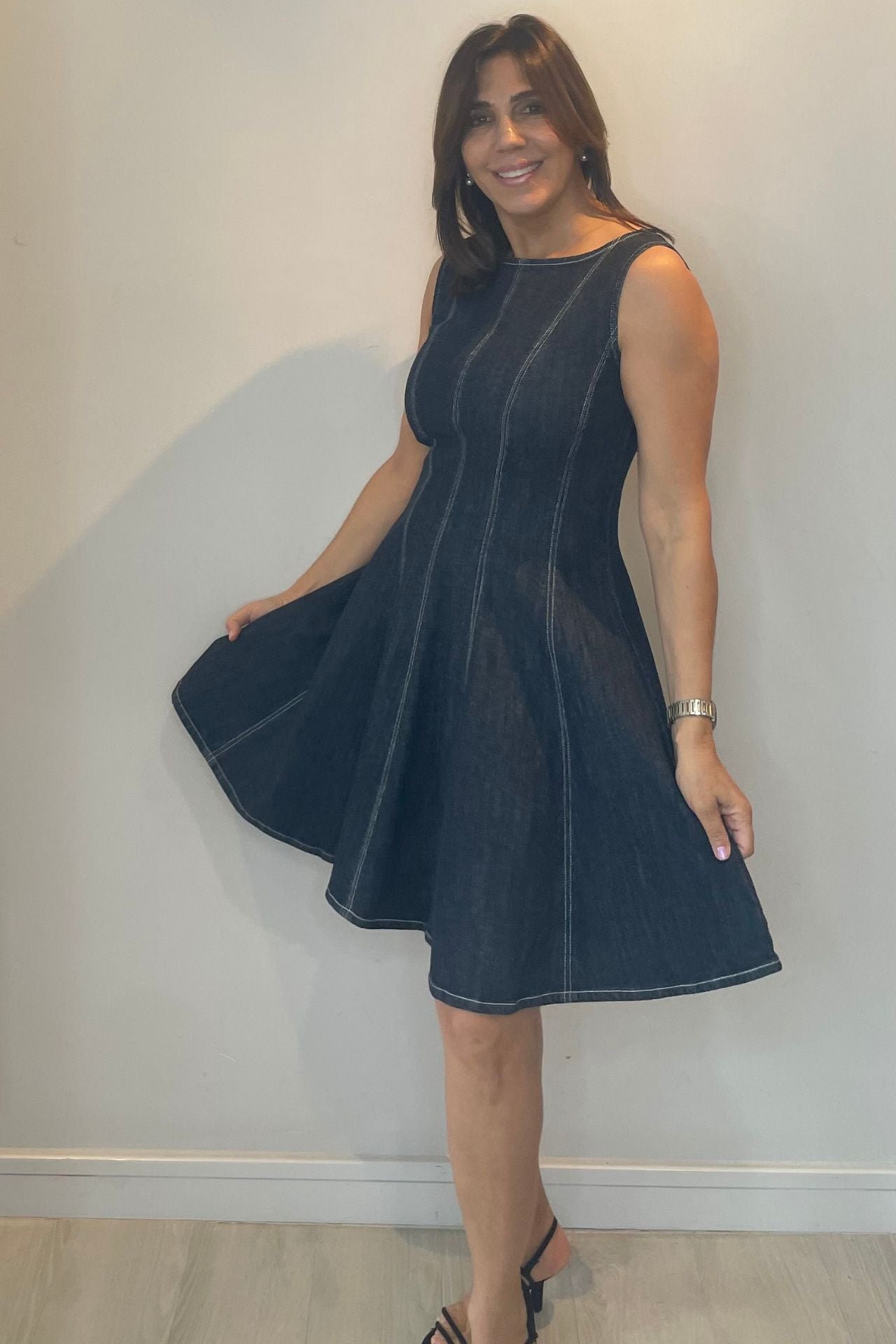 Woman wearing a dark blue dress against a plain background