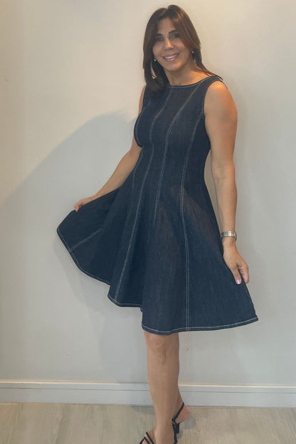 Woman wearing a dark blue dress against a plain background