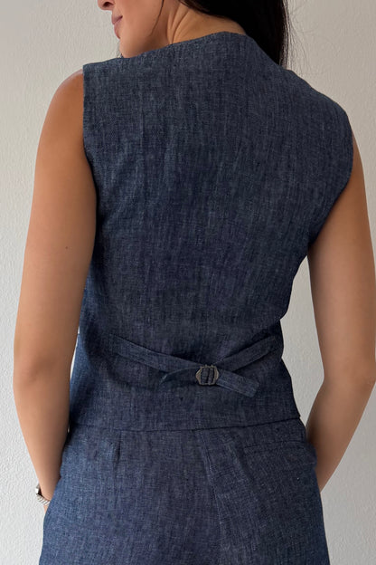 Model wearing the Midnight Tailored Vest in navy linen featuring a sleeveless tailored silhouette, front button closure, and adjustable back buckle detail.