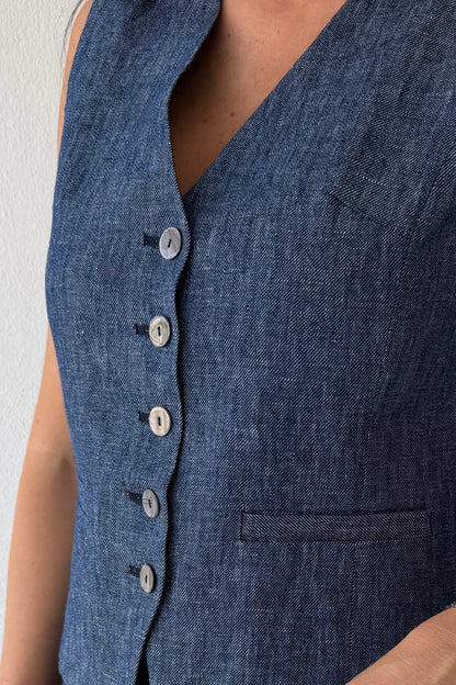 Model wearing the Midnight Tailored Vest in navy linen featuring a sleeveless tailored silhouette, front button closure, and adjustable back buckle detail.