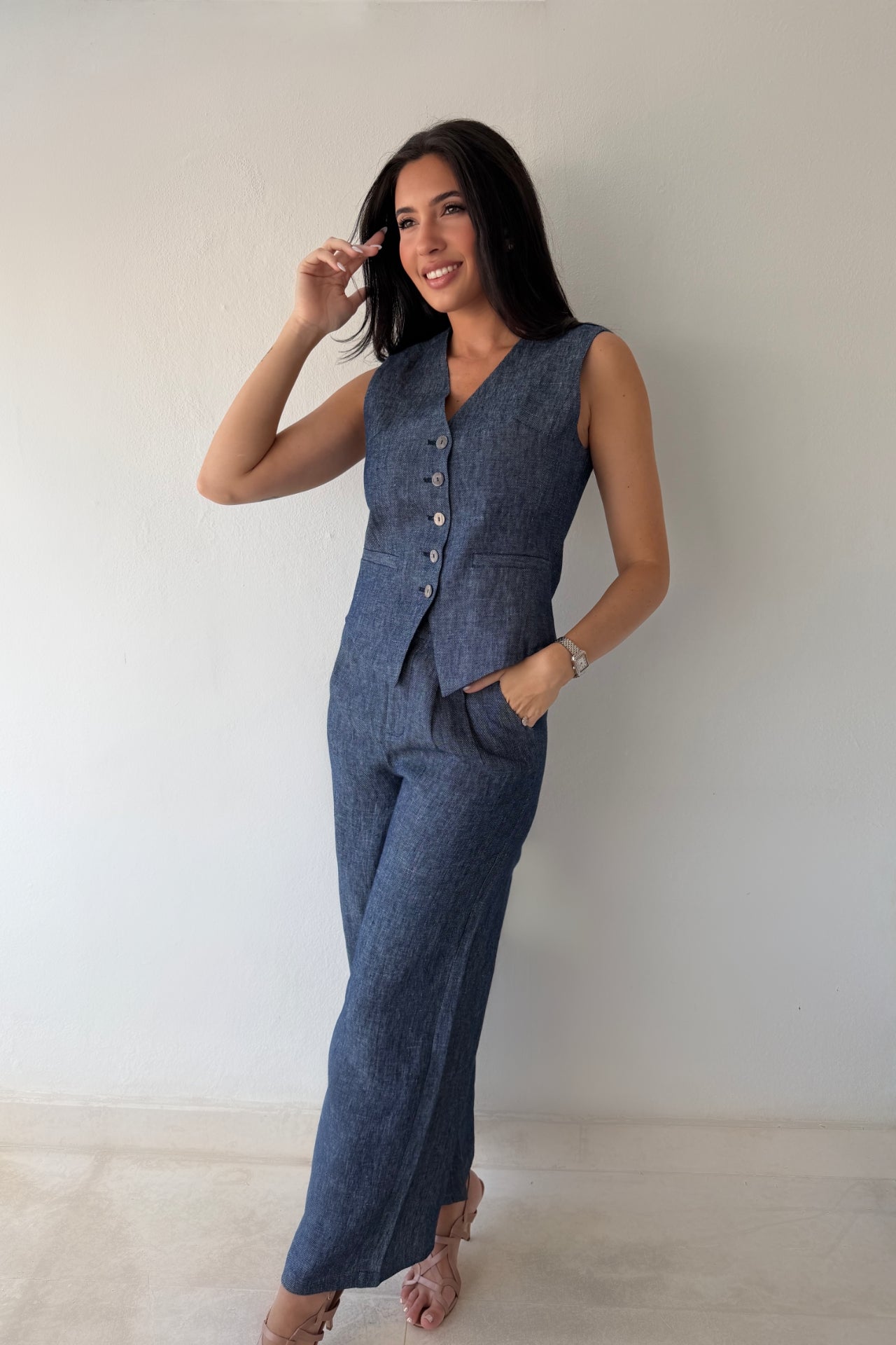 Model wearing the Midnight Tailored Vest in navy linen featuring a sleeveless tailored silhouette, front button closure, and adjustable back buckle detail.