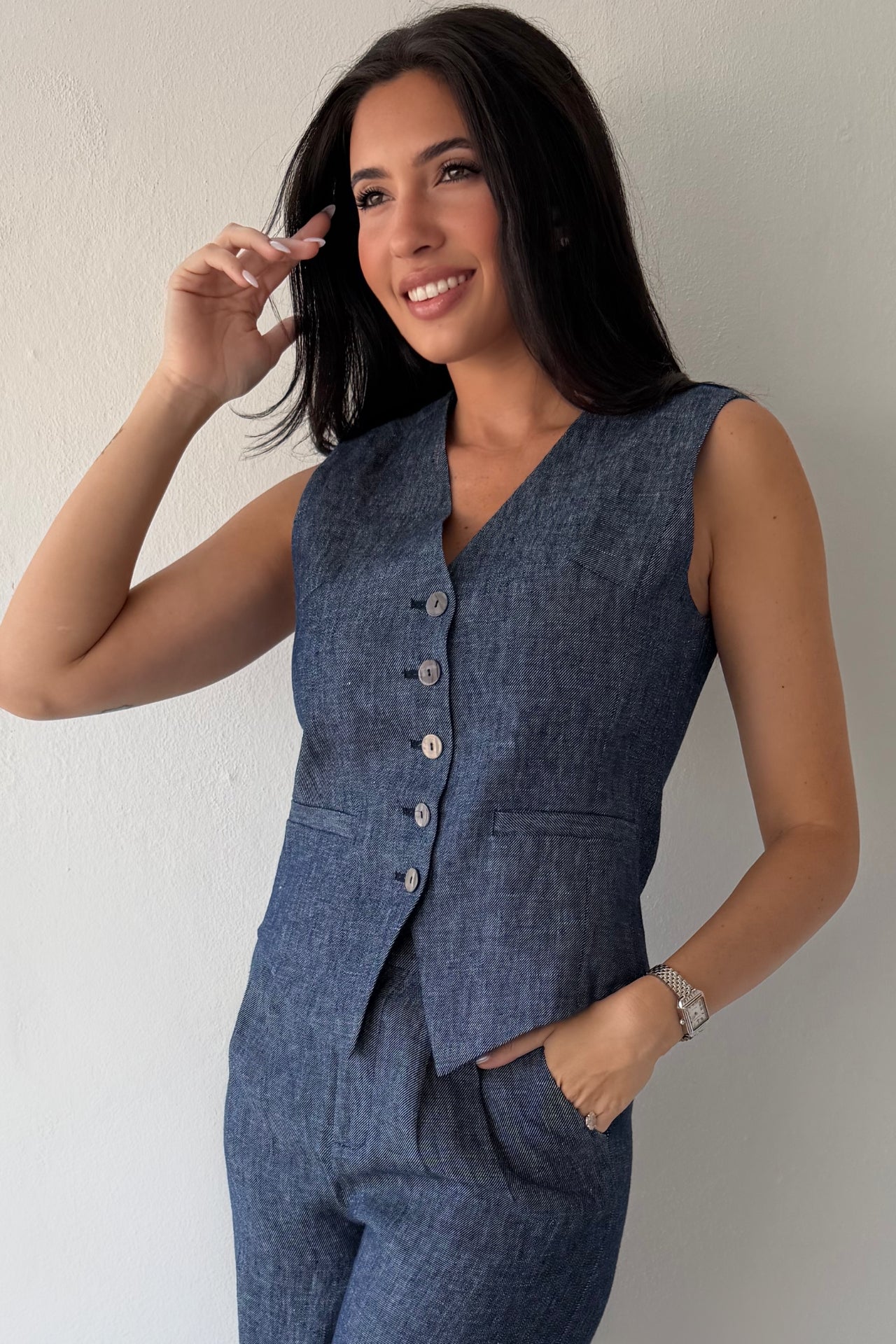 Model wearing the Midnight Tailored Vest in navy linen featuring a sleeveless tailored silhouette, front button closure, and adjustable back buckle detail.