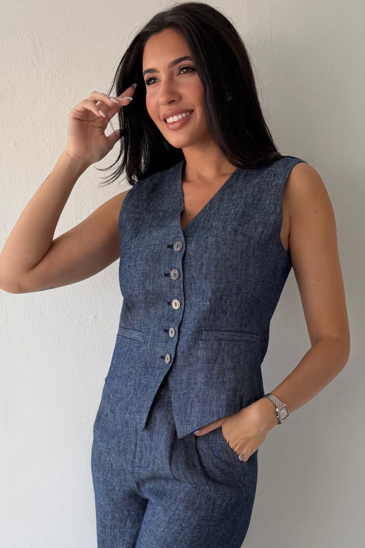 Model wearing the Midnight Tailored Vest in navy linen featuring a sleeveless tailored silhouette, front button closure, and adjustable back buckle detail.
