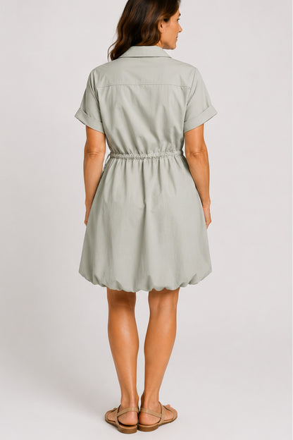Mineral gray cinched shirt dress with button-front design, adjustable waist, roll-tab sleeves, and side pockets styled for elegant everyday wear.