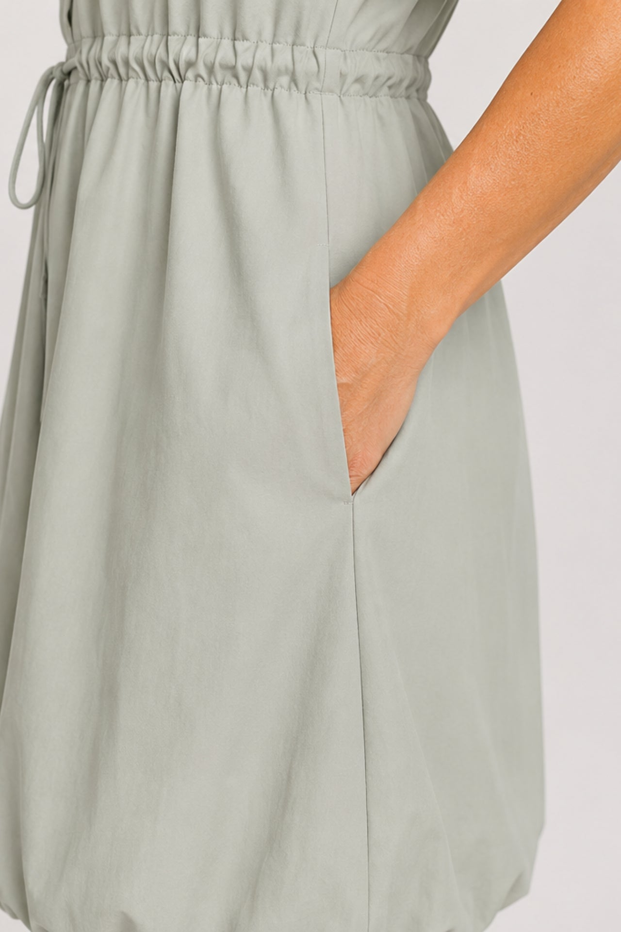 Mineral gray cinched shirt dress with button-front design, adjustable waist, roll-tab sleeves, and side pockets styled for elegant everyday wear.