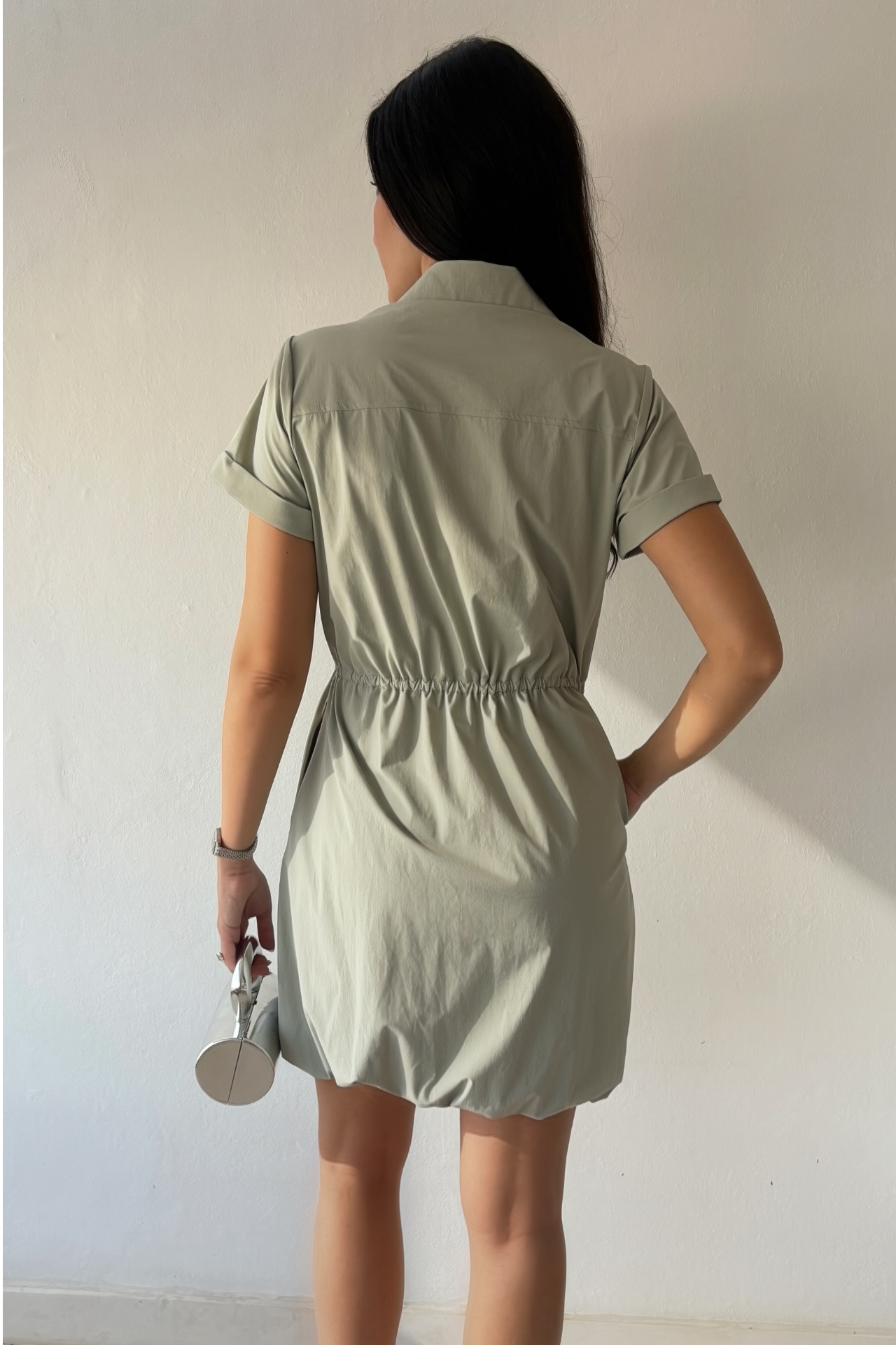 Mineral gray cinched shirt dress with button-front design, adjustable waist, roll-tab sleeves, and side pockets styled for elegant everyday wear.