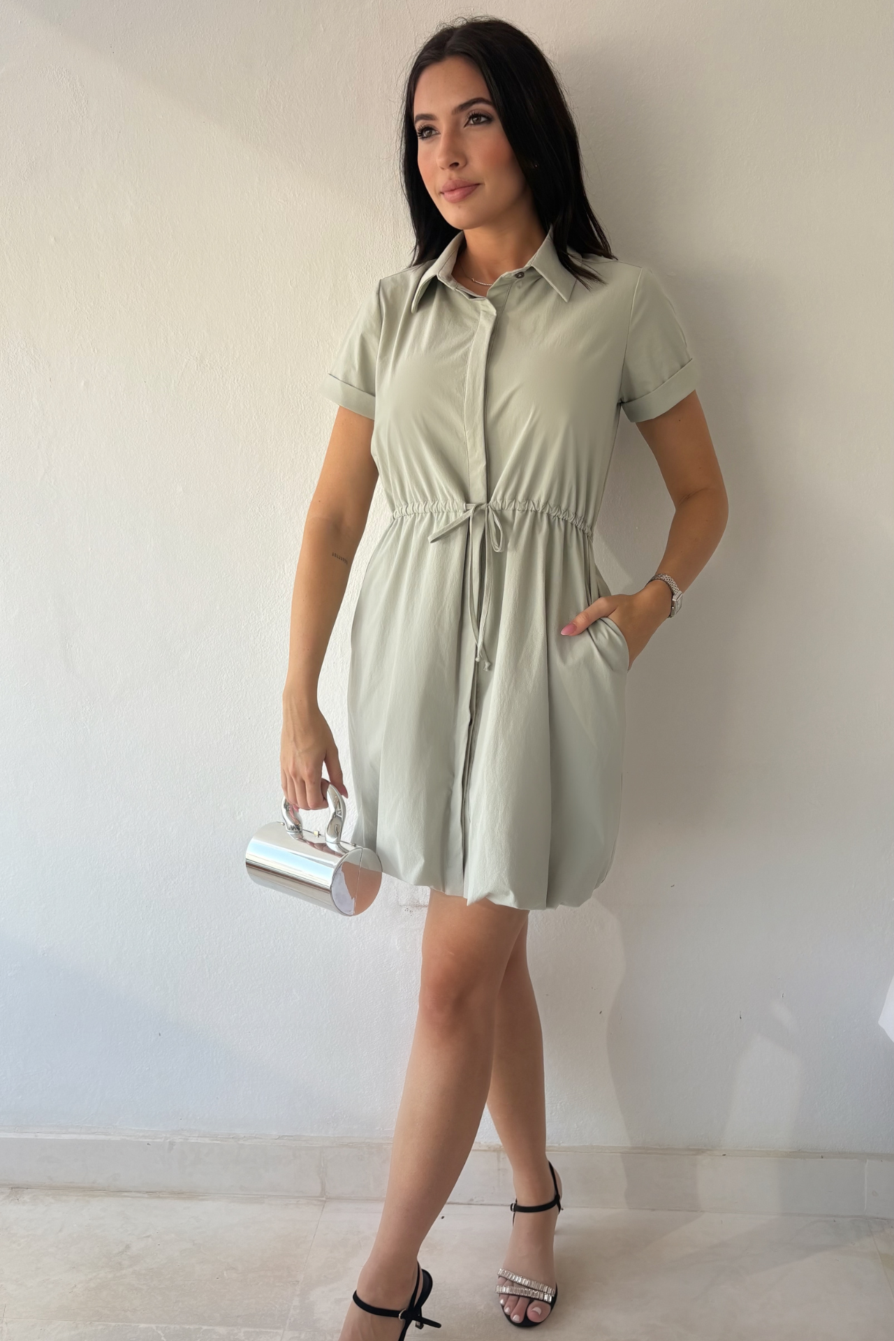 Mineral gray cinched shirt dress with button-front design, adjustable waist, roll-tab sleeves, and side pockets styled for elegant everyday wear.