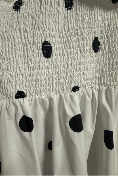 Close-up of Monroe Polka Dress showing black polka dot cotton fabric and smocked elastic detailing