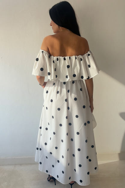 Monroe Polka Dress in white cotton with black polka dots, off-the-shoulder ruffle neckline and maxi silhouette