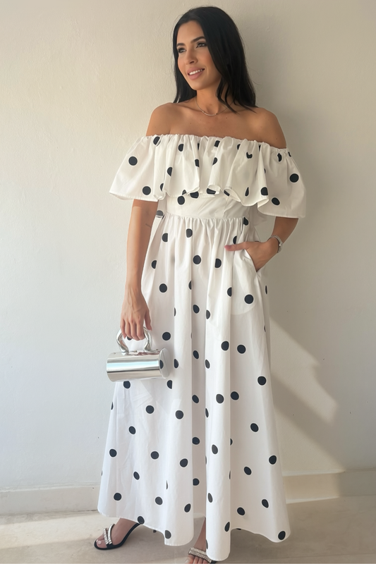 Monroe Polka Dress in white cotton with black polka dots, off-the-shoulder ruffle neckline and maxi silhouette