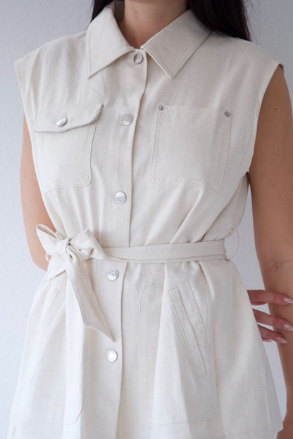 Natural sleeveless vest with buttons on a plain background