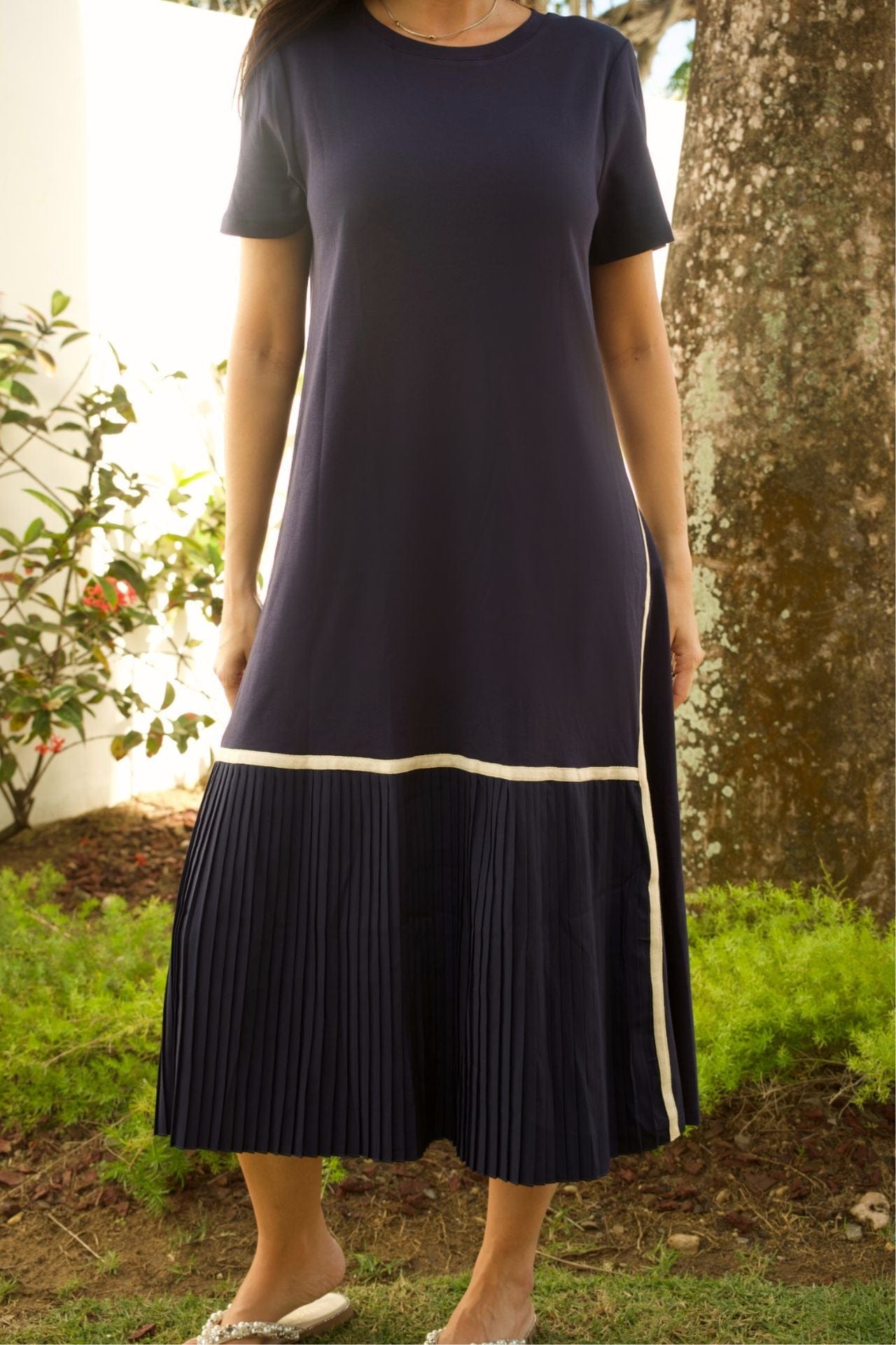 Close-up of pleated hem and knit fabric texture of navy maxi dress.