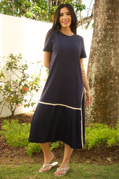 Model wearing navy knit maxi dress with pleated hem – elegant and flowy silhouette.