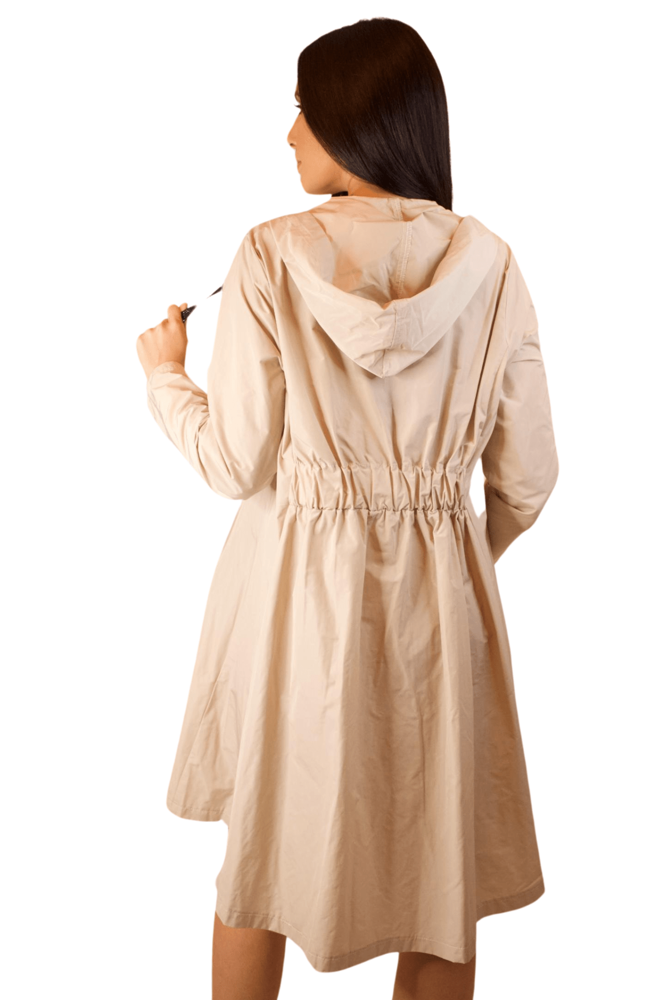 A woman wearing a beige long sleeve raincoat with a black zipper and a hoodie.