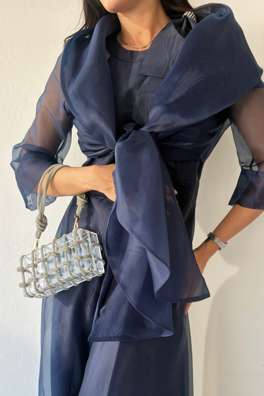 Sheer navy organza wrap with tie-front styling and three-quarter sleeves over navy jumpsuit